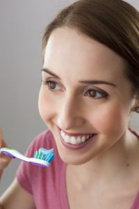 smiling woman holding tooth brush 
